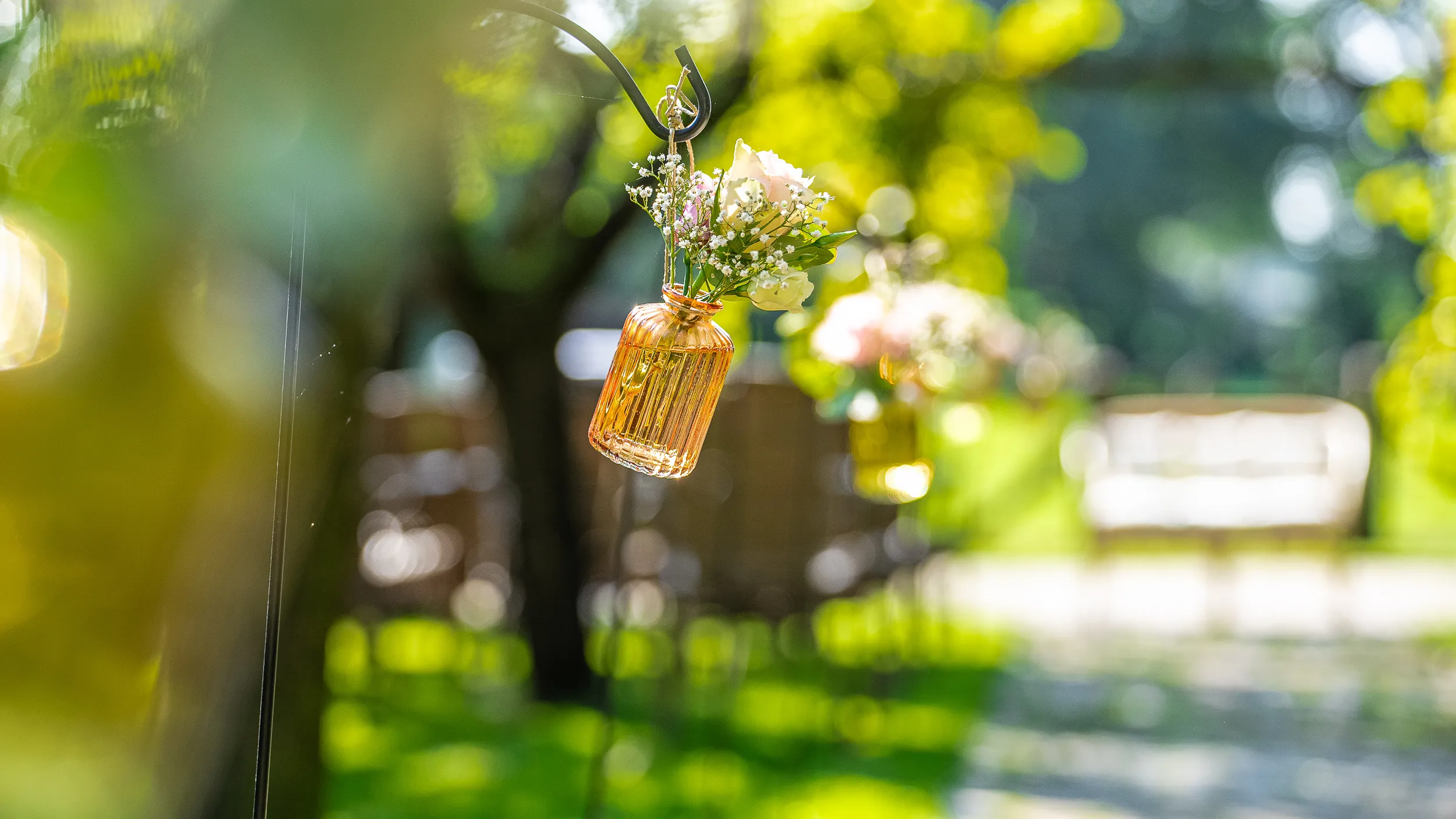 Vaasjes met bloemen aan de stoelen in de tuin