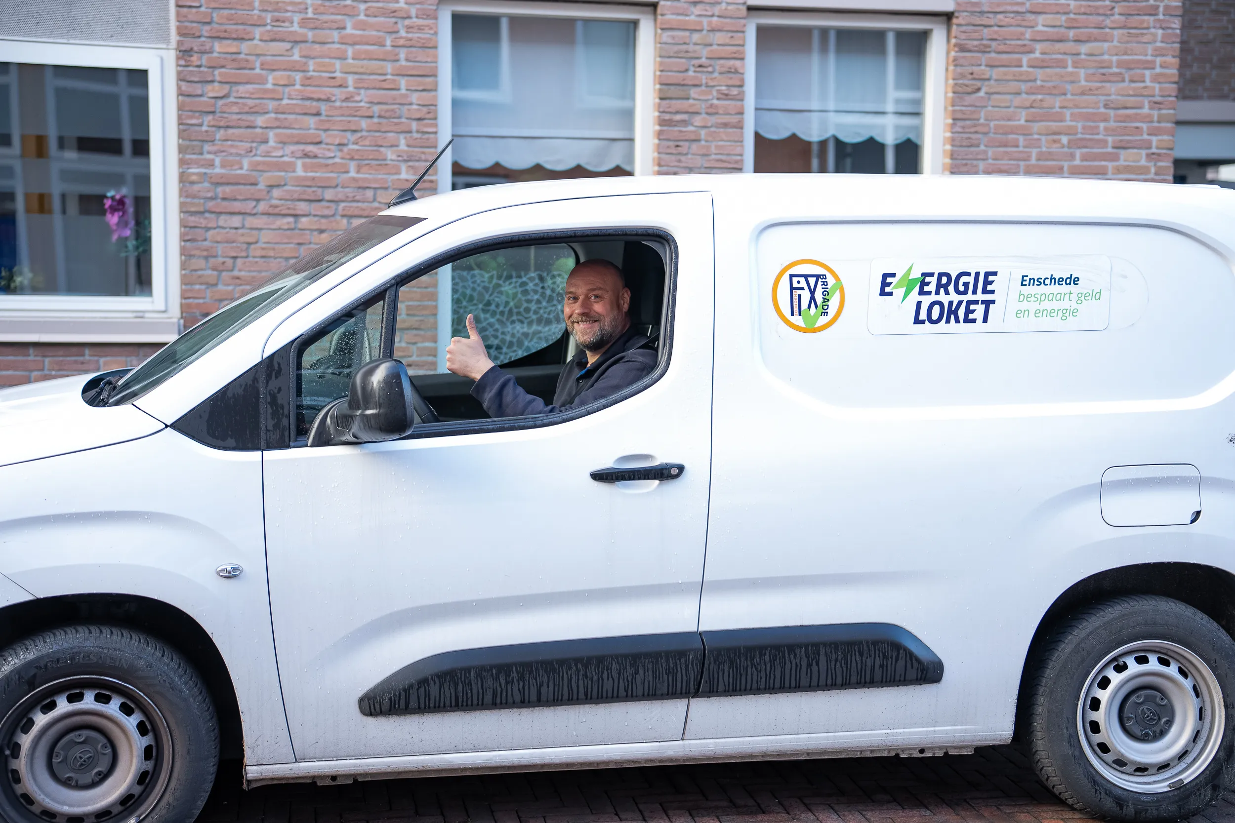 Medewerker van het Energieloket steekt zijn duim op vanuit de bus