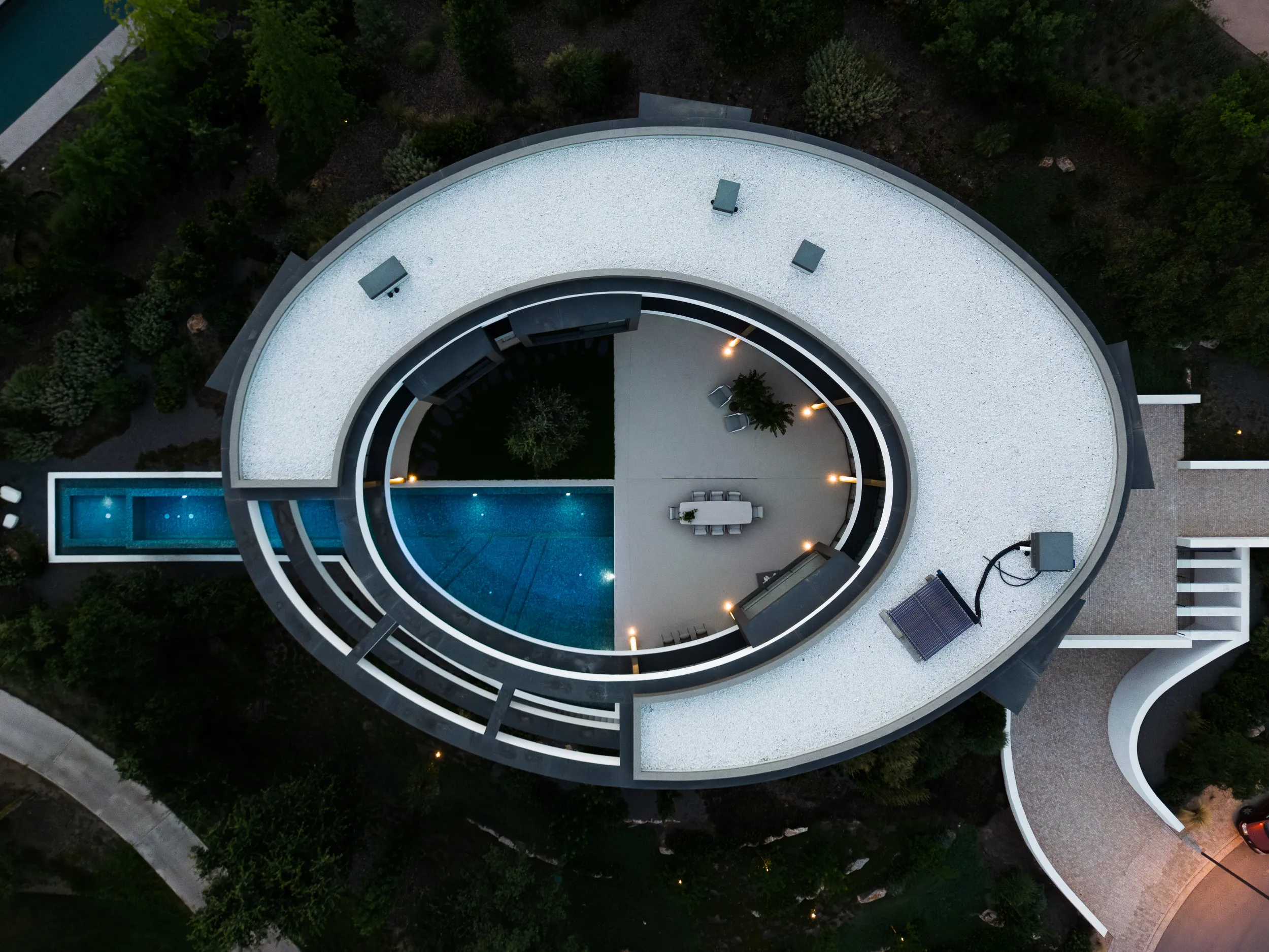 Luchtfoto van het ronde dak en zwembad van de villa bij avond