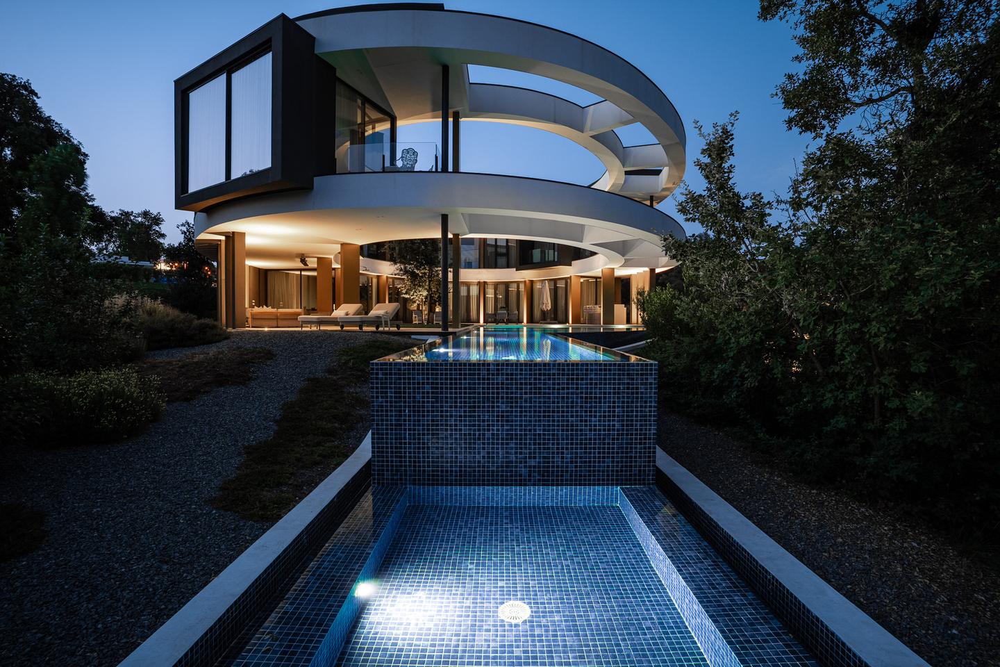 De villa in Girona in de schemering, met verlicht zwembad