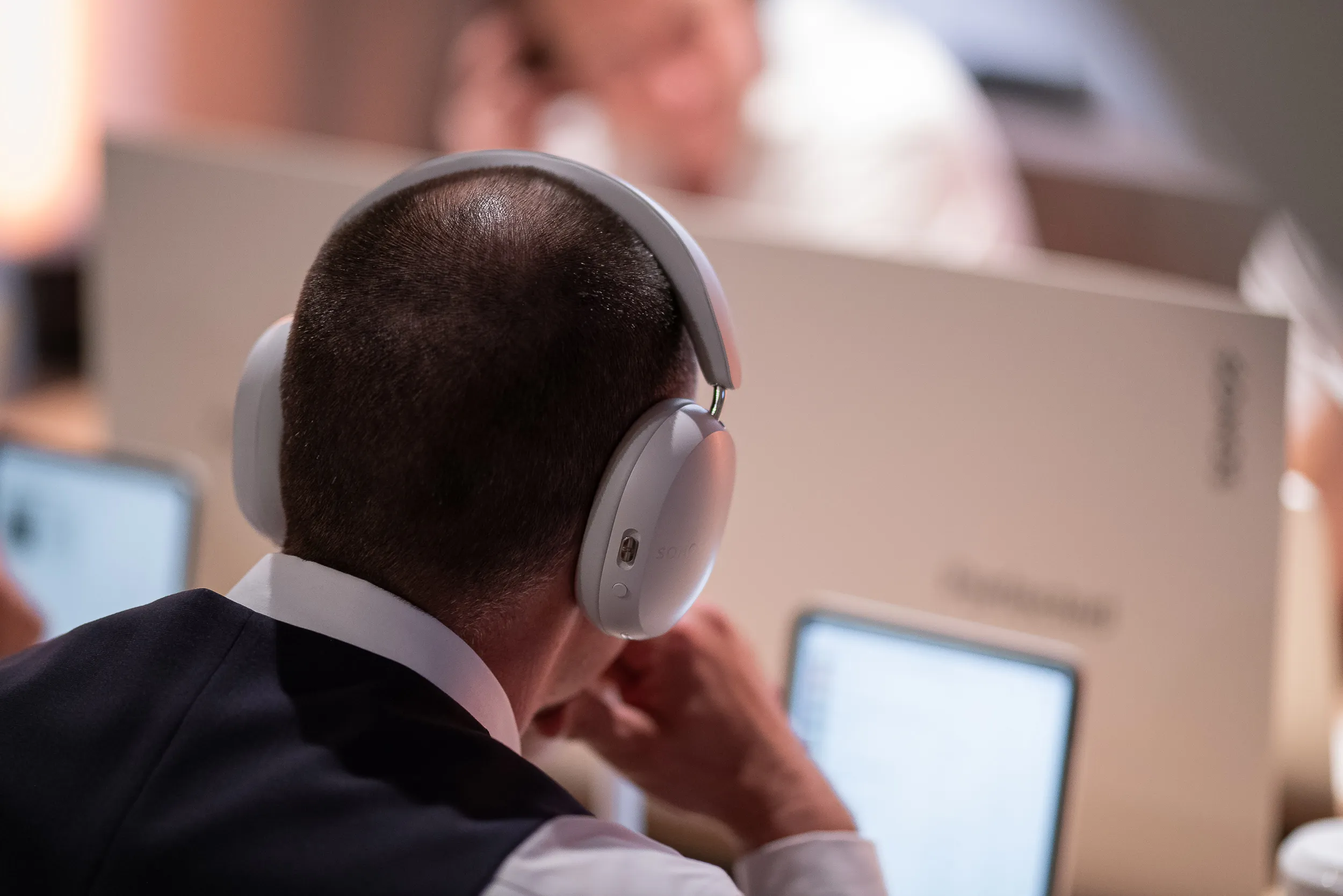 Bezoeker luistert met een Sonos Ace koptelefoon