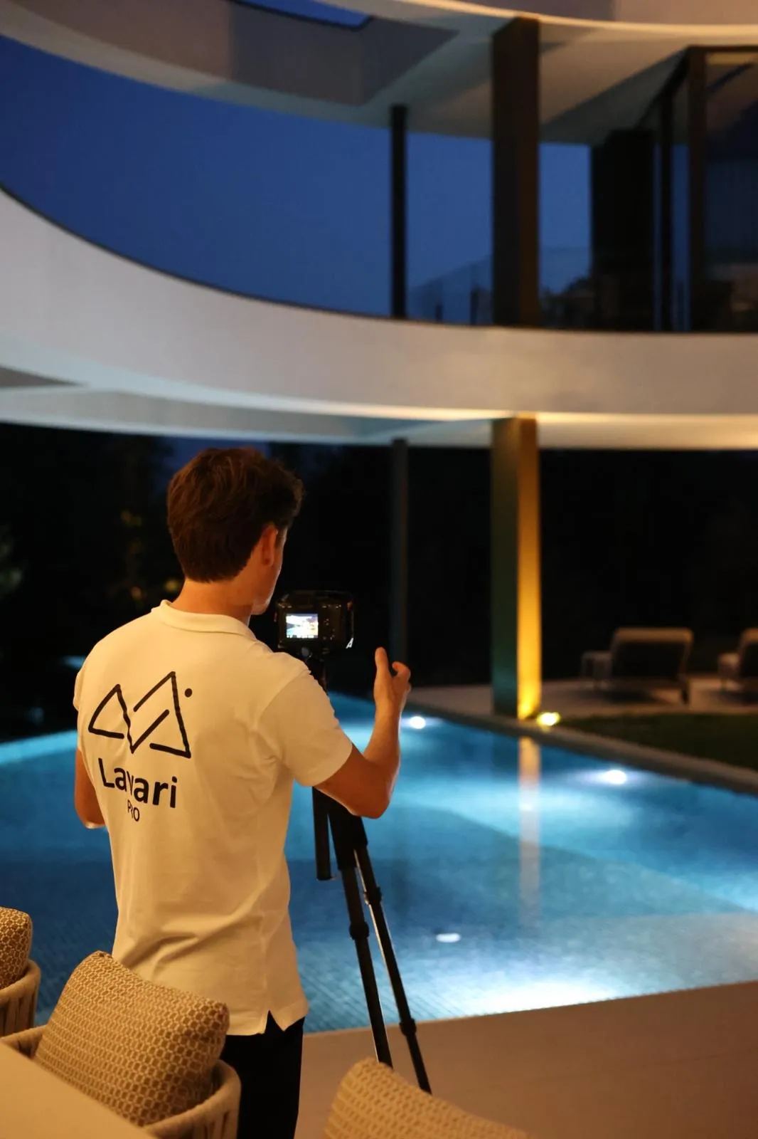 Lavari Pro filmt bij een verlicht zwembad in de avond